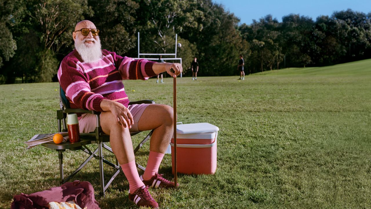 Senior man sitting in a picnic chair at a sports oval Senior man sitting in a picnic chair at a sports oval