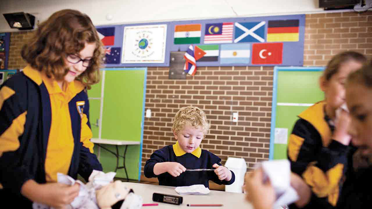School children of mixed ages, making paper chatterboxes. School children of mixed ages, making paper chatterboxes.