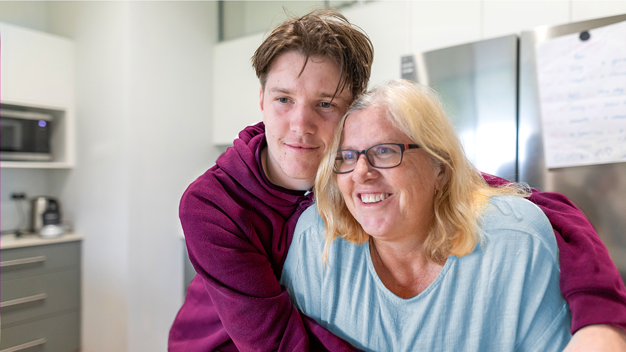Young man hugging a smiling older woman